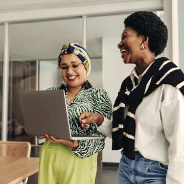 Woman smiling with her financial advisor as they look at a computer