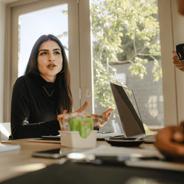 Young woman discussing her financial future with a financial advisor at a desk with a sunny window behind