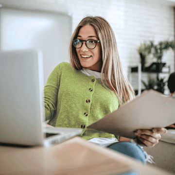 Woman in a green sweater on a virtual call with a financial planner 